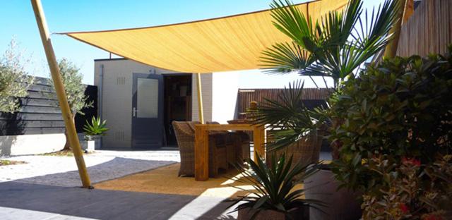 Terras met schaduwdoek en beplanting
