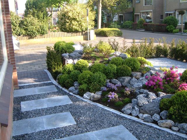 Voortuin in aanleg met rotsen en beplanting