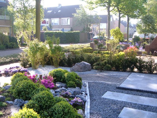 Voortuin met hoekborder van keien en heesters