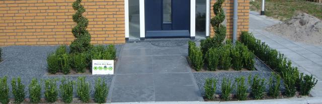 Moderne voortuin met strakke bestrating en siergrassen